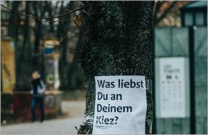 Plakat an einem Baum mit der Aufschrift "Was liebst Du an deinem Kiez?"