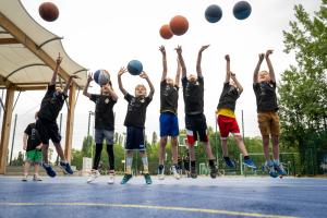 Kinder springen hoch und werfen Basketbälle in die Luft