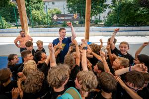 Kinder jubeln mit ihrem Trainer