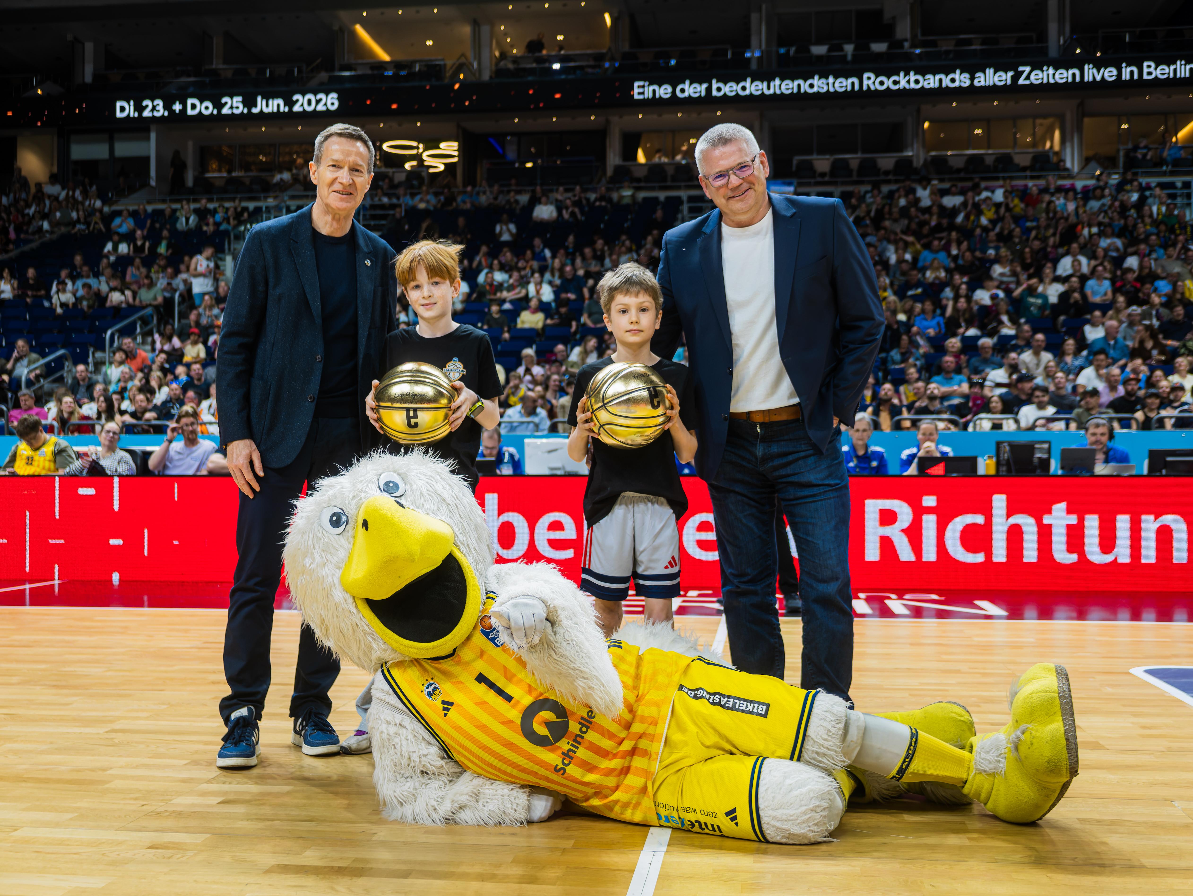 BEA-Geschäftsführer Michael Geißler, die Kiezcamp-Gewinner Leo und Fritz, "Charlotte"-Vorstand Dirk Enzesberger und der Albatros auf dem Spielfeld von ALBA Berlin. Foto: Tilo Wiedensohler